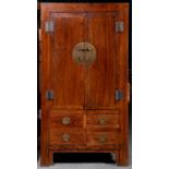 A South East Chinese brass mounted hardwood wardrobe,  the lower part fitted with four drawer,