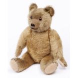 A head-turning teddy bear, second quarter 20th c, of blond mohair with felt pads, black stitches and