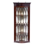 An Edwardian serpentine mahogany hanging corner cabinet, with lancet arched glazing bars, 122cm h;