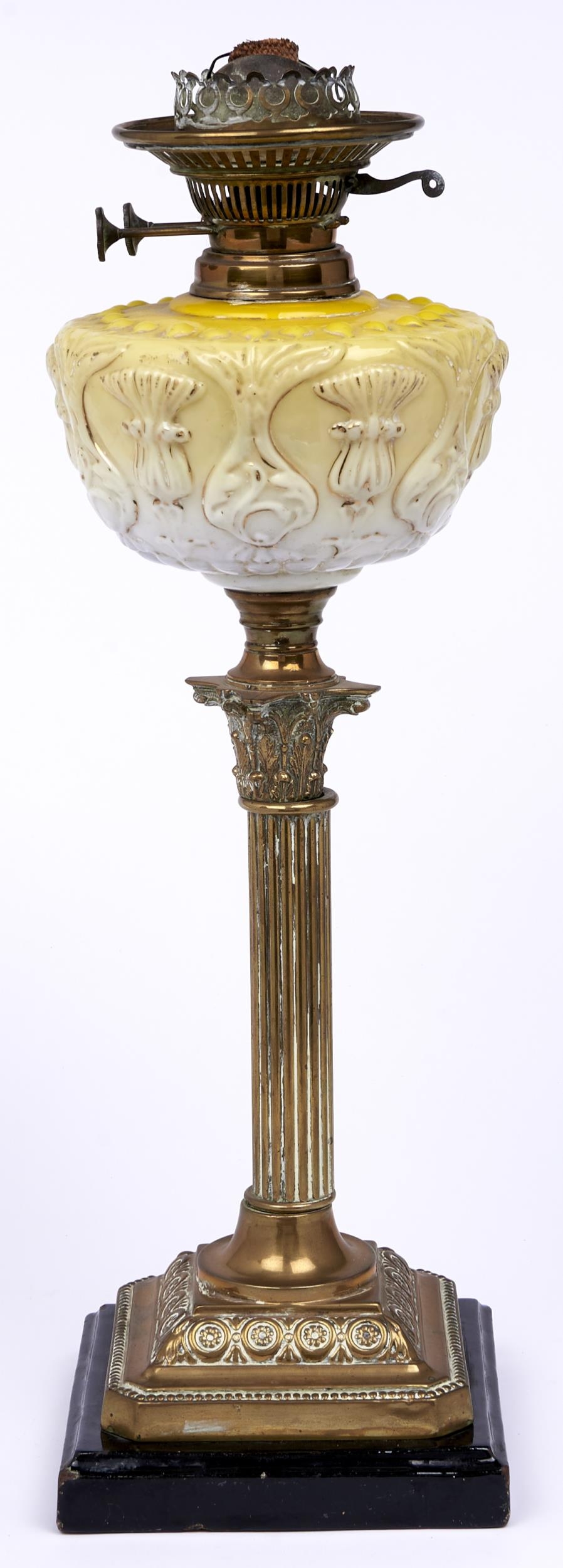 An Edwardian brass Corinthian column oil lamp, with press moulded and gilt yellow glass fount and