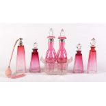 A Victorian press moulded glass and cranberry glass cruet, with plated covers or faceted stoppers,