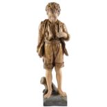 A Goldscheider cold painted terracotta figure of a boy, c1900, standing on a rustic stump moulded