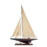 A painted wood model yacht, with cotton sails and rigging, beam 62cm, 84cm h, mounted on a stand