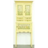 A painted cupboard on stand, 20th c, flared cornice above a pair of panelled doors painted with