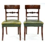 A pair of William IV mahogany dining chairs, the curved top rail carved with two S-scrolls above