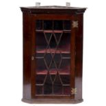 A mahogany splay fronted hanging corner cupboard, 19th c, with dentil cornice and lozenge pattern