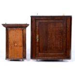 An oak splay fronted hanging corner cupboard, with panelled door, 70cm h; 34 x 86cm and a smaller