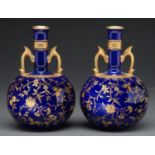 A pair of Mintons cobalt ground bone china drumstick vases, c1900, with raised gilt naturalistic