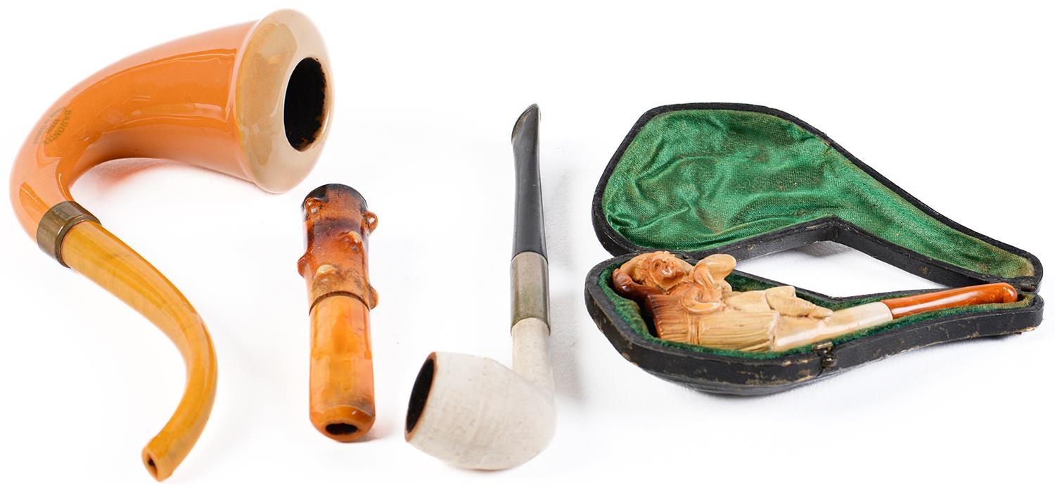 A Baronite tobacco pipe, a meerschaum cheroot holder carved with a gleaner, early 20th c, cased, etc