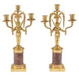 A pair of French ormolu candelabra, 20th c, of three lights borne by Putto, on cylindrical marble