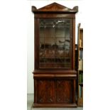 A William IV mahogany bookcase, the figured pediment with acroteria above similarly figured