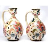 A pair of Zsolnay ewers, late 19th c, decorated with flowers and scrolling foliage, 20cm h,