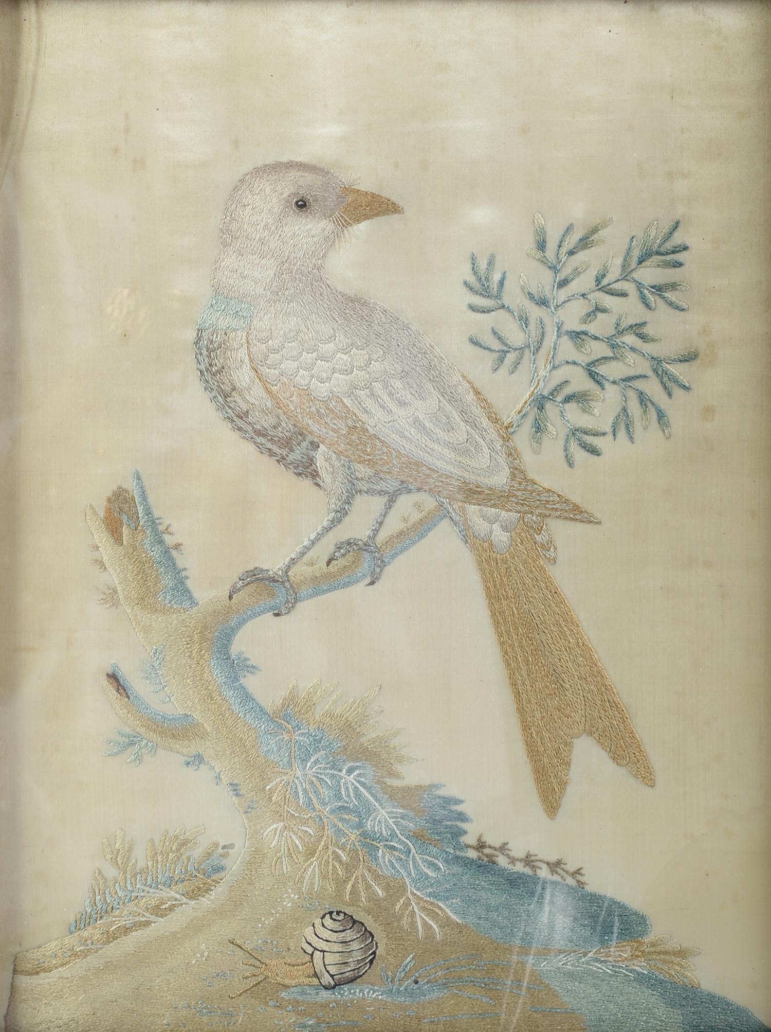 An embroidered silk picture of a bird on a branch, a snail at the base of the tree,  worked in