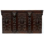 An oak overmantel, 17th century and later,  of three geometrically moulded sections, each centred by