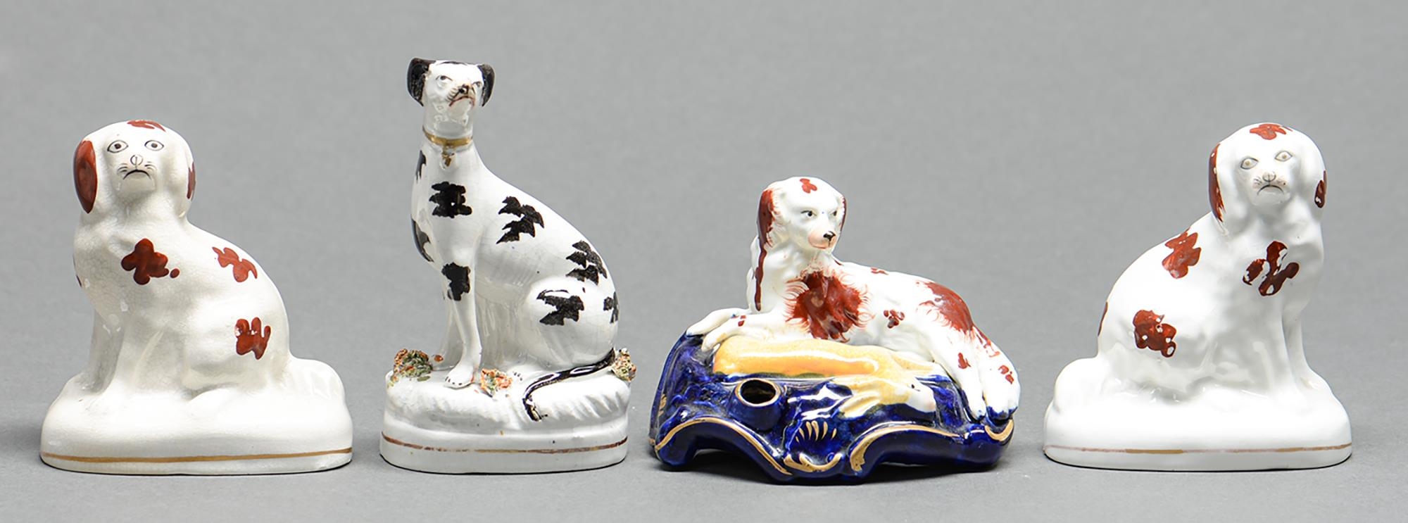 Four Staffordshire earthenware models of dogs, mid 19th c, including a quill holder in the form of a