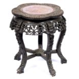 A Chinese carved hardwood stand, c1900, with pink stone inset top, 47cm h; 41cm diam Much old