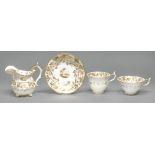 A Rockingham cream jug and trio, c1830-42, of three spur handle shape, painted with a central