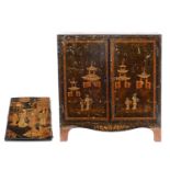 A Regency japanned table cabinet, early 19th c, fitted with drawers enclosed by a pair of doors,