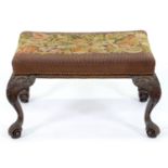 A mahogany stool, early 20th c,  in George II style, covered in stuffed over floral gros point