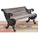 A Victorian garden seat, the cast iron ends of scrolling floral design, seat height 43cm, 132cm l