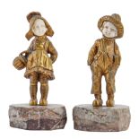 C Boilly.  A pair of gilt bronze and ivory statuettes of a school boy and girl, early 20th c