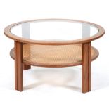 A round teak coffee table, c1970, with glass top and caned undertier, on four flat fluted legs, 44cm