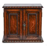 An oak smoker's cabinet, early 20th c, the fitted interior enclosed by panelled doors, 28.5cm h;