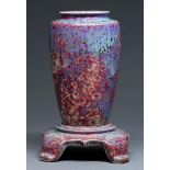 A Ruskin flambe glazed vase and stand, 1926, the vase of shouldered form and covered in a fine
