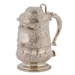 A George III silver tankard, crisply but later chased with flowers and festoons centred by a