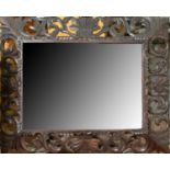 A Victorian carved and dark stained oak mirror, the rectangular bevelled plate in splayed frame of