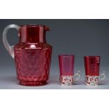 A late Victorian cranberry glass dimpled jug and a pair of beakers in silver holders, jug 20cm h,