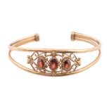 A garnet bangle, in 9ct gold, 60mm (internal), marks obscured, 11.3g ConditionGood condition