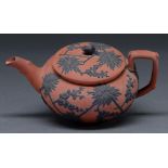 A Wedgwood Rosso Antico teapot and cover, c1820, ornamented in black stoneware with prunus and