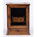 An Edwardian oak and inlaid smoker's cabinet, with fitted interior, glazed door and drawer, 38cm h