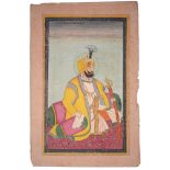 An Indian miniature of a ruler, seated in yellow turban and robe, bears ink stamp verso, 24.5 x