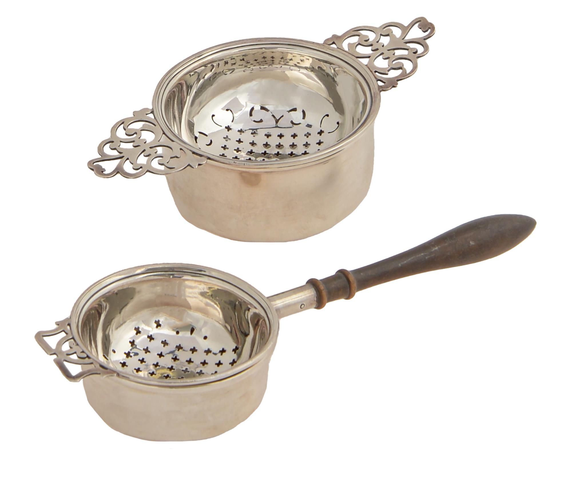 Two Elizabeth II silver tea strainers and stands, one with turned pearwood handle, 12.5 and 163.