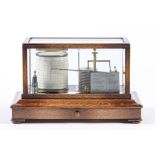 An oak barograph, c1930, with lacquered brass mechanism, bevelled glass lights and chart drawer to