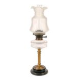 An Edwardian brass columnar oil lamp,  with faceted glass fount and brass burner, on black glaed