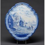 A Dutch  delftware  blue and white wall plaque in integral frame, 20th c, painted with a village