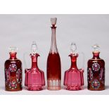 Two pairs of cranberry glass decanters and claret jugs and stoppers, c1900 and later, the