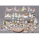 A collection of Continental glazed and biscuit porcelain pin cushion and boudoir dolls, similar