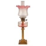 An Edwardian brass columnar oil lamp, with faceted glass fount, 60.5cm h excluding chimney