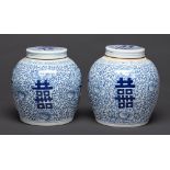A pair of Chinese blue and white jars and covers, 20th c, painted with flowers and prominent shou