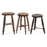 Three Victorian ash and elm three or four legged stools, with turned or iron stretchers, 47-53cm h