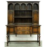 An oak dresser, c1930, the boarded rack with spice cupboards, 200cm h; 55 x 151cm Top somewhat