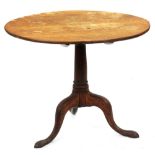 A George III oak tripod table, the round tip-up top on turned pillar, 68cm h; 83cm diam Top faded