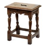 An oak joined stool, early 20th c, in Charles II style, the pierced seat above channelled sides,