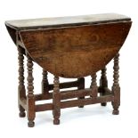 A George II oak gateleg table, with bobbin turned legs, 75cm h; 91 x 107cm Much encrusted with old