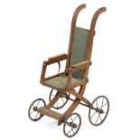 An Edwardian oak folding doll's pushchair, on iron wheels with solid rubber tyres, 78cm h Complete