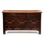 A George III oak mule chest, the lid with ovolo lip above geometric panelled front and two